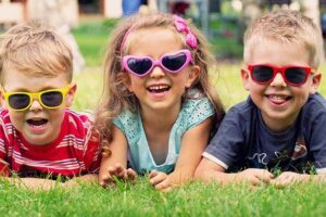 Summer Camp in Holmdel, NJ, where a group of 3 children are smiling with sunglasses on